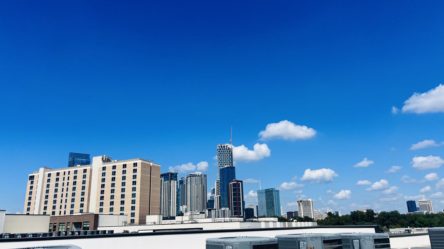Downtown Austin skyline view from the rooftop, blue sky with a few clouds